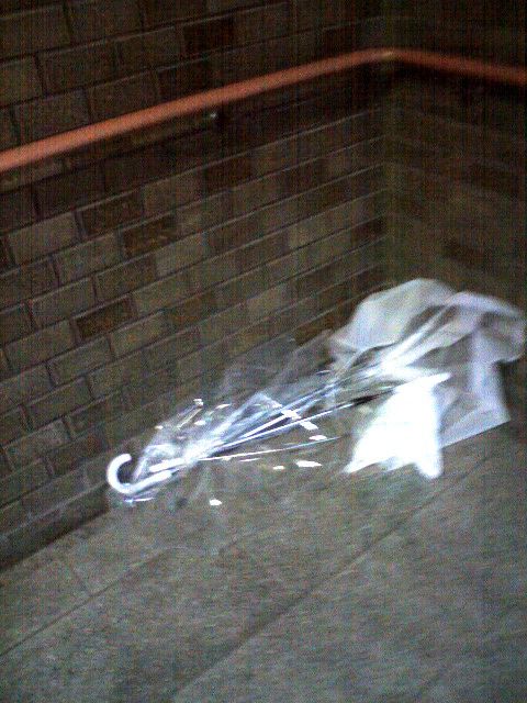 階段の踊り場に投げられた傘